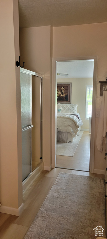Bathroom featuring wood finished floors, a stall shower, and baseboards
