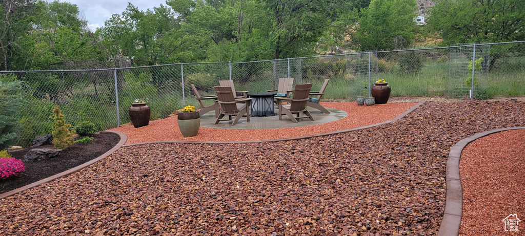 View of yard featuring a patio, fence, and a fire pit