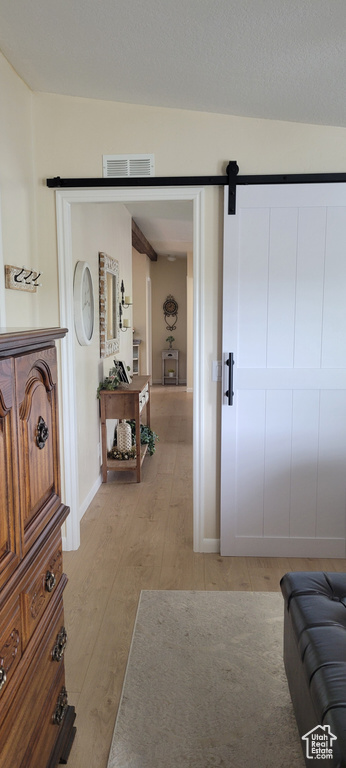 Interior space featuring light wood-style flooring, baseboards, and a barn door