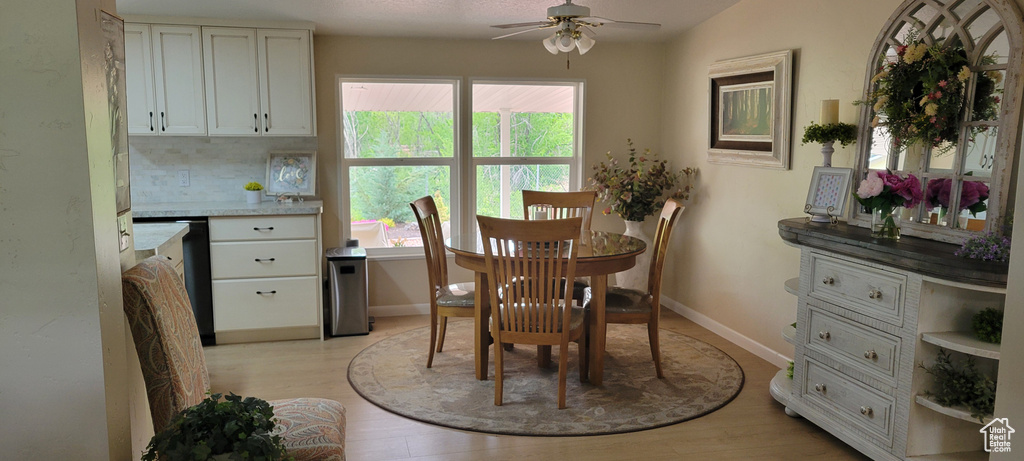 Dining space with a ceiling fan, baseboards, and light wood-style flooring