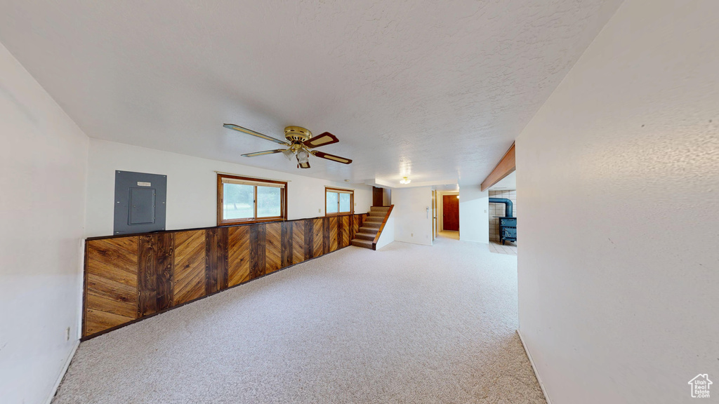 Carpeted empty room with electric panel and ceiling fan