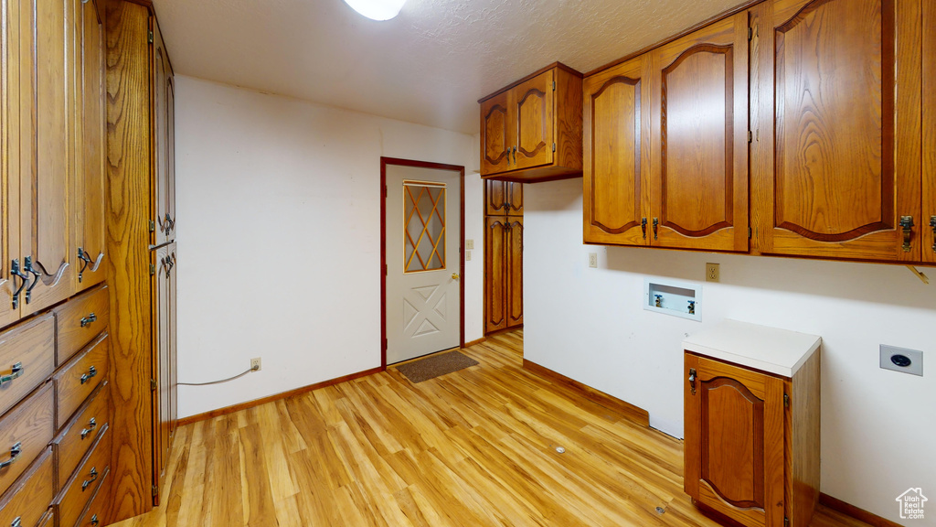 Laundry room with washer hookup, hookup for an electric dryer, cabinet space, light wood-type flooring, and baseboards