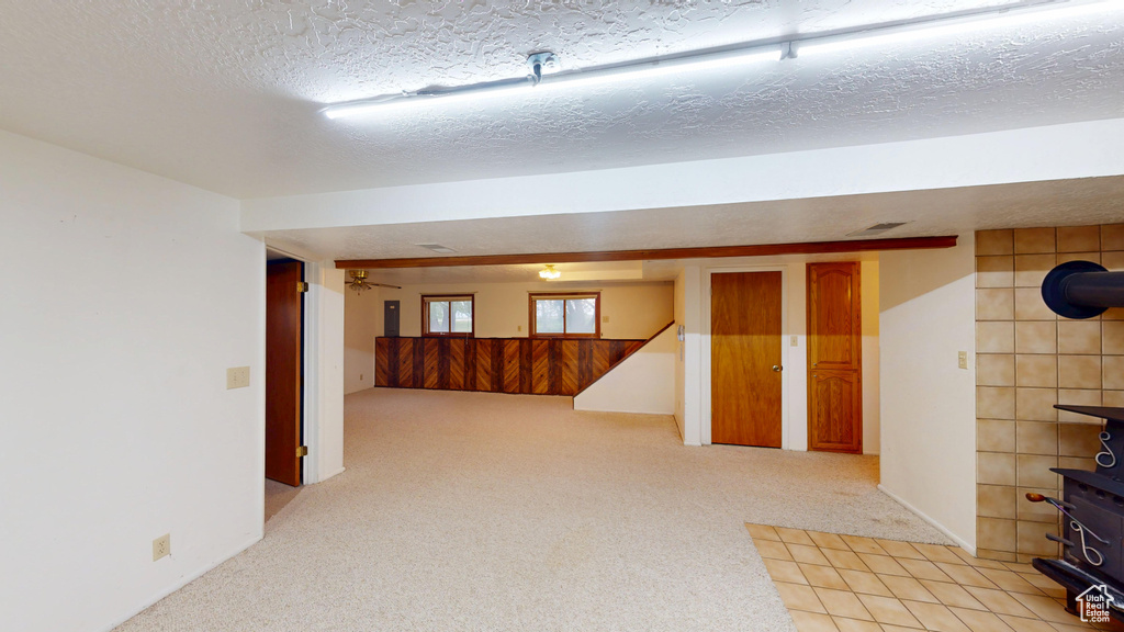 Below grade area featuring light colored carpet and a textured ceiling
