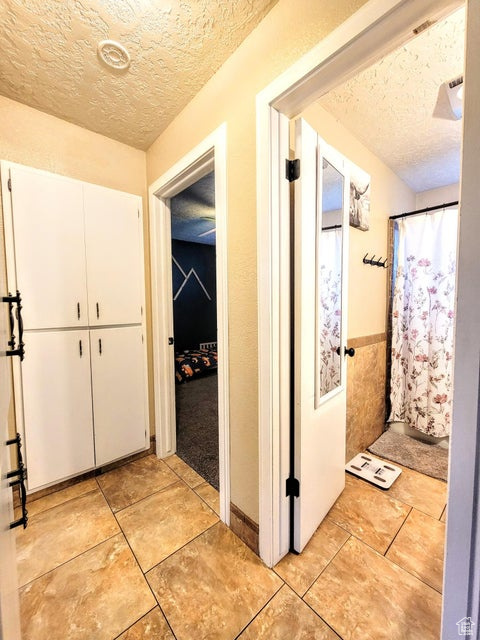 Hallway featuring a textured ceiling