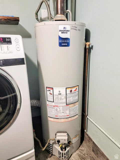 Utility room featuring water heater and washer / dryer