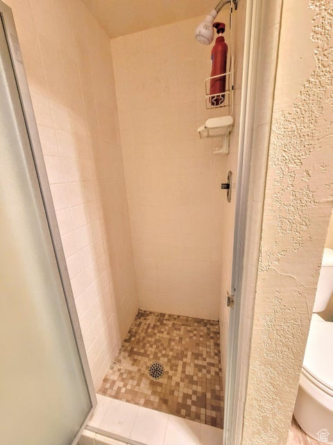 Bathroom featuring a shower stall and toilet