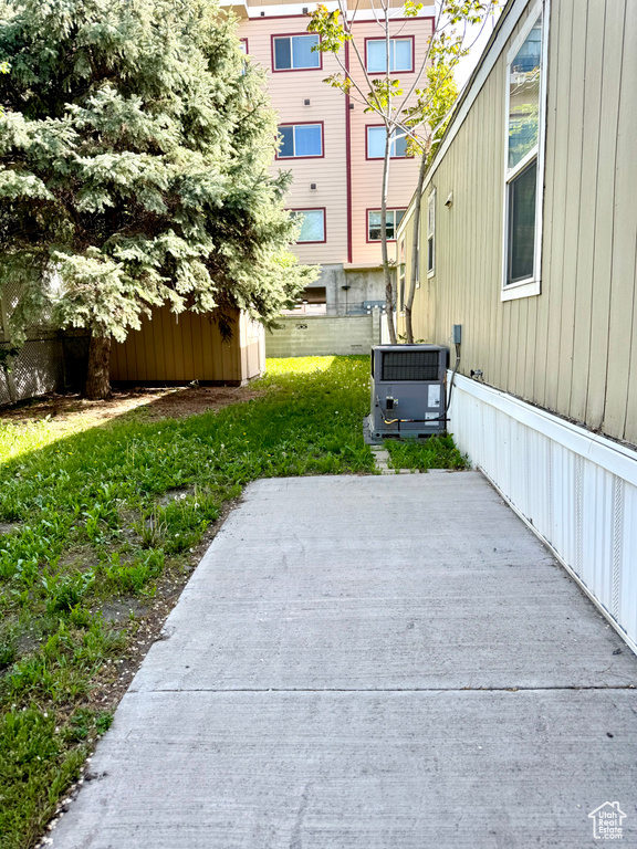 View of patio / terrace with central AC, fence, and an outbuilding