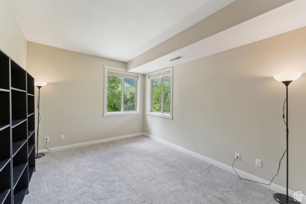 Carpeted spare room featuring baseboards
