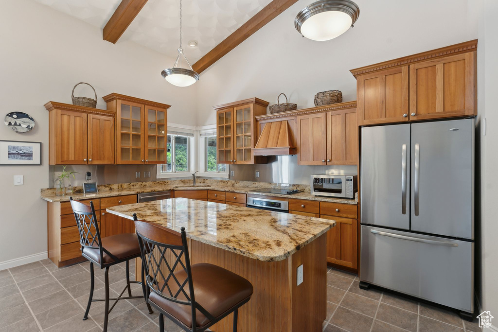 Kitchen featuring appliances with stainless steel finishes, a sink, beam ceiling, high vaulted ceiling, and dark tile patterned floors