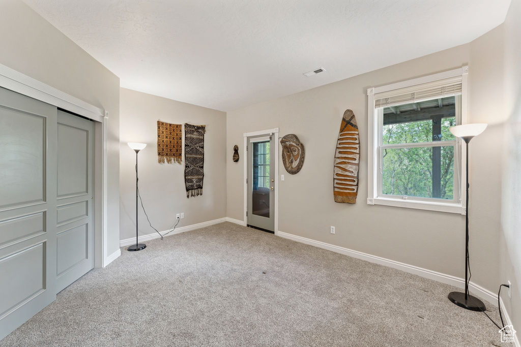 Carpeted entrance foyer featuring healthy amount of natural light and baseboards