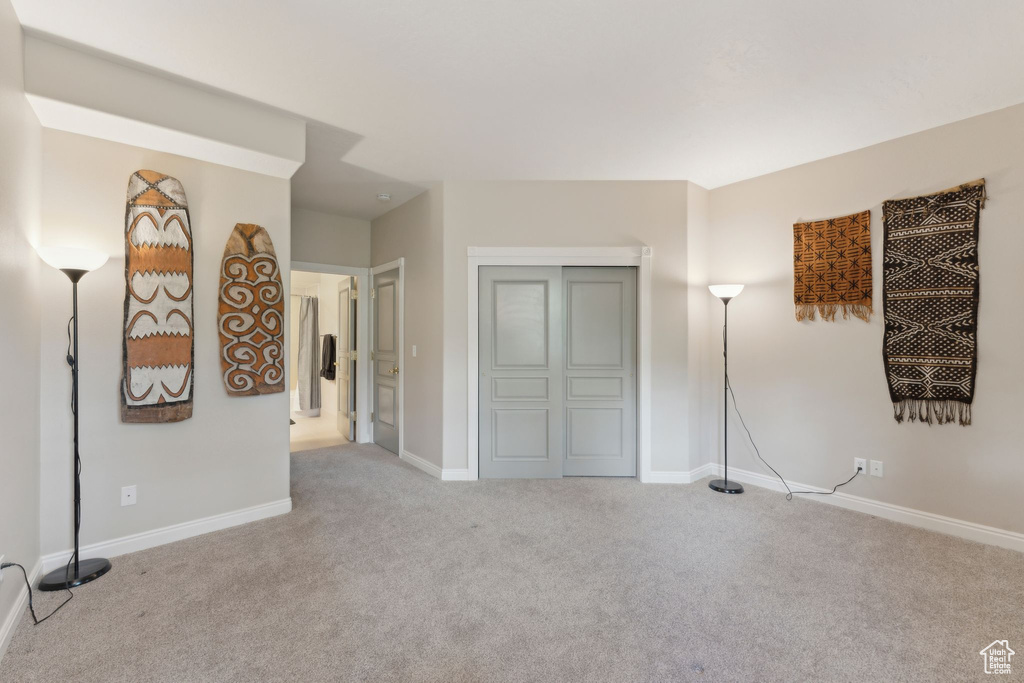 Unfurnished living room with light colored carpet and baseboards
