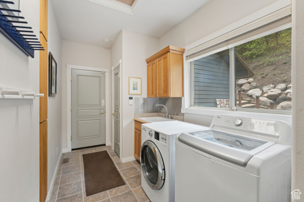 Laundry area featuring cabinet space, independent washer and dryer, baseboards, and stone finish floors