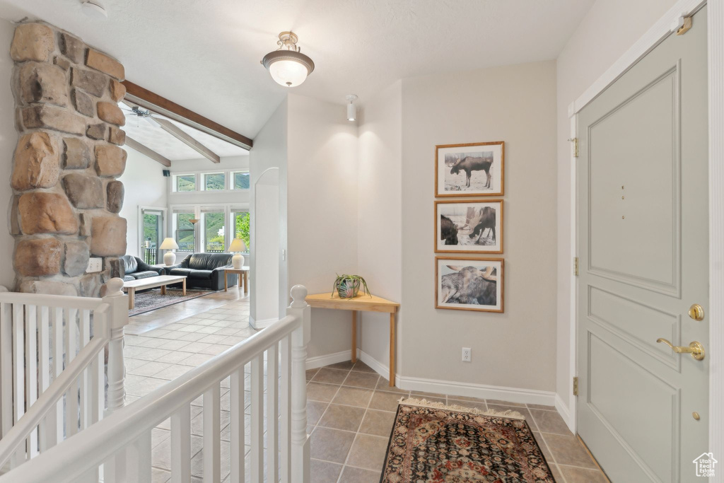 Foyer entrance featuring ceiling fan, baseboards, and light tile patterned floors