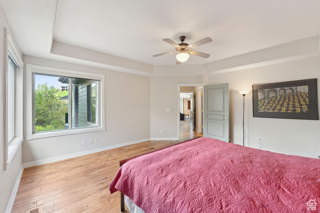 Bedroom with light wood-style flooring, baseboards, and a ceiling fan