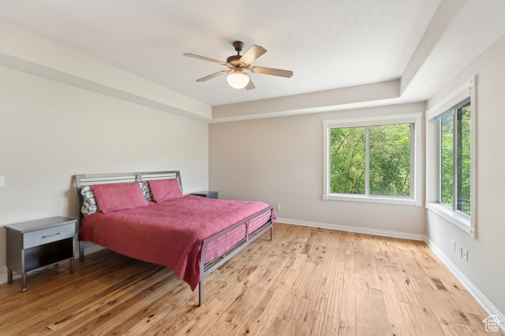 Bedroom with light wood-style flooring, baseboards, and ceiling fan