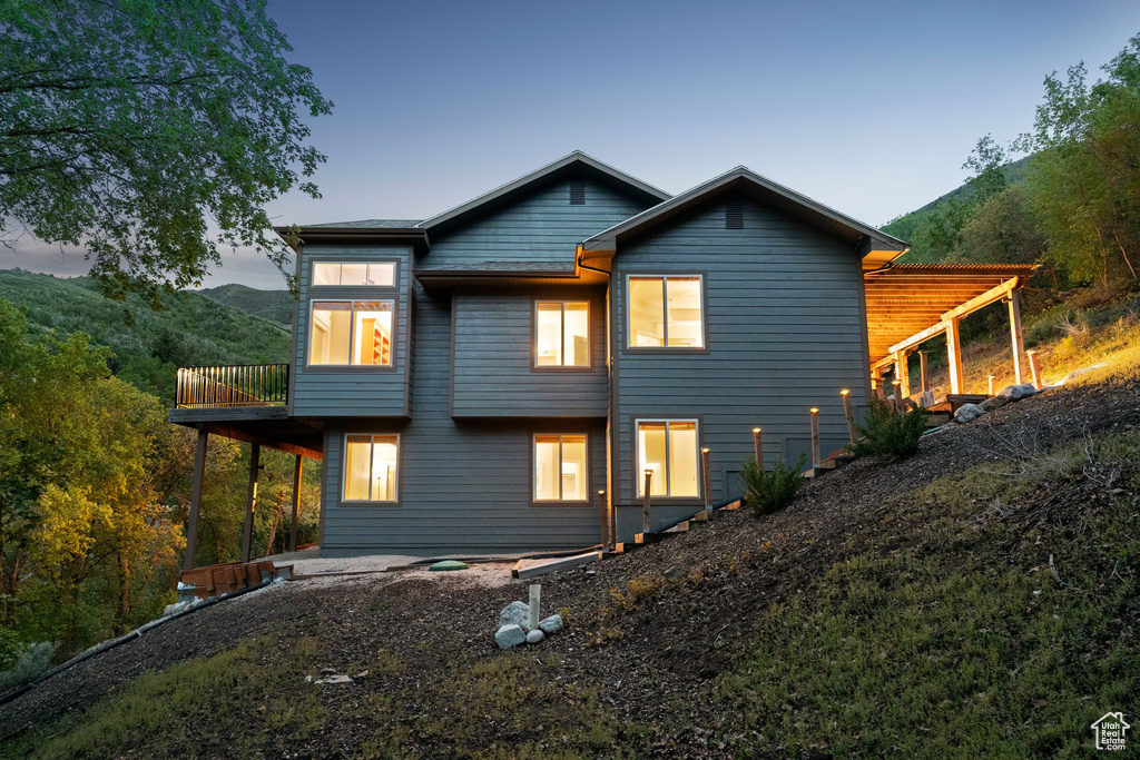 Rear view of property featuring a mountain view and a balcony