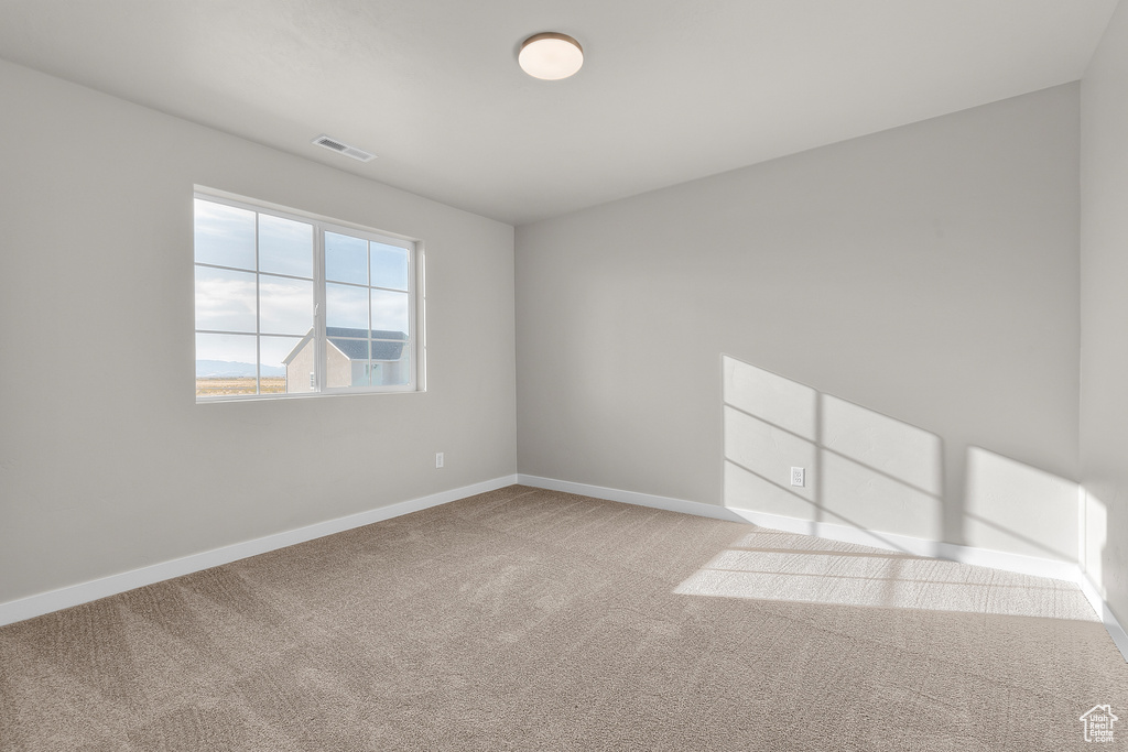 Carpeted empty room with baseboards