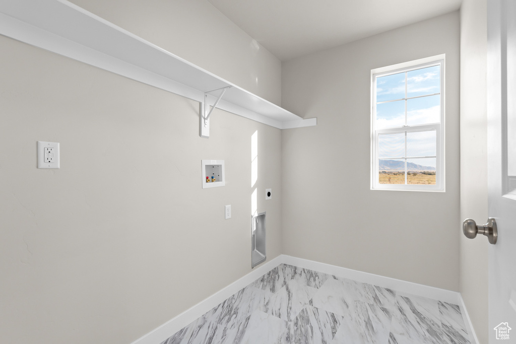 Clothes washing area featuring washer hookup, baseboards, electric dryer hookup, and light marble finish flooring