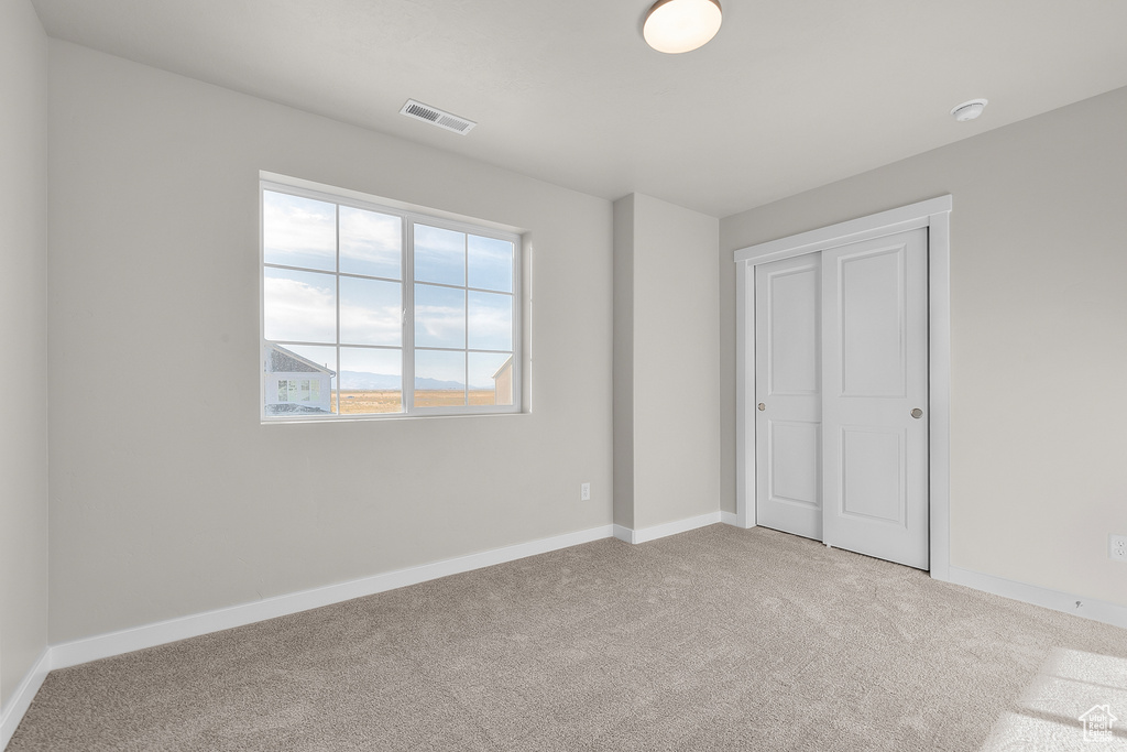Unfurnished bedroom with carpet floors and baseboards