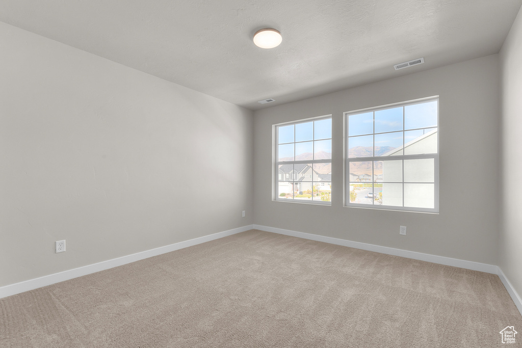 Empty room featuring baseboards and carpet