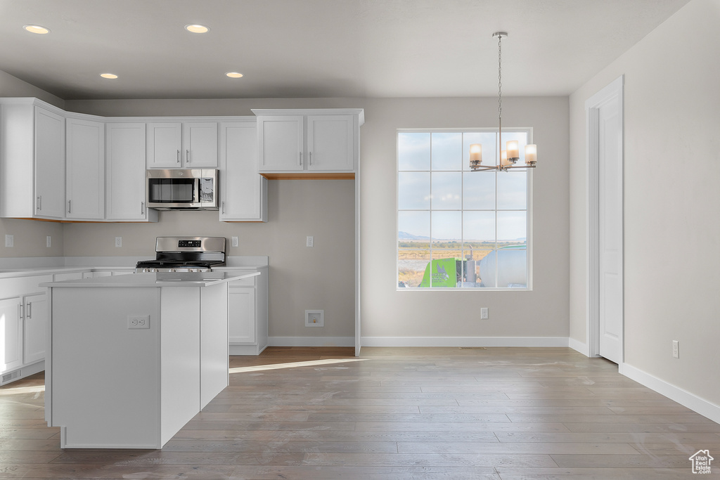 Kitchen featuring stainless steel appliances, white cabinetry, a chandelier, light countertops, and recessed lighting