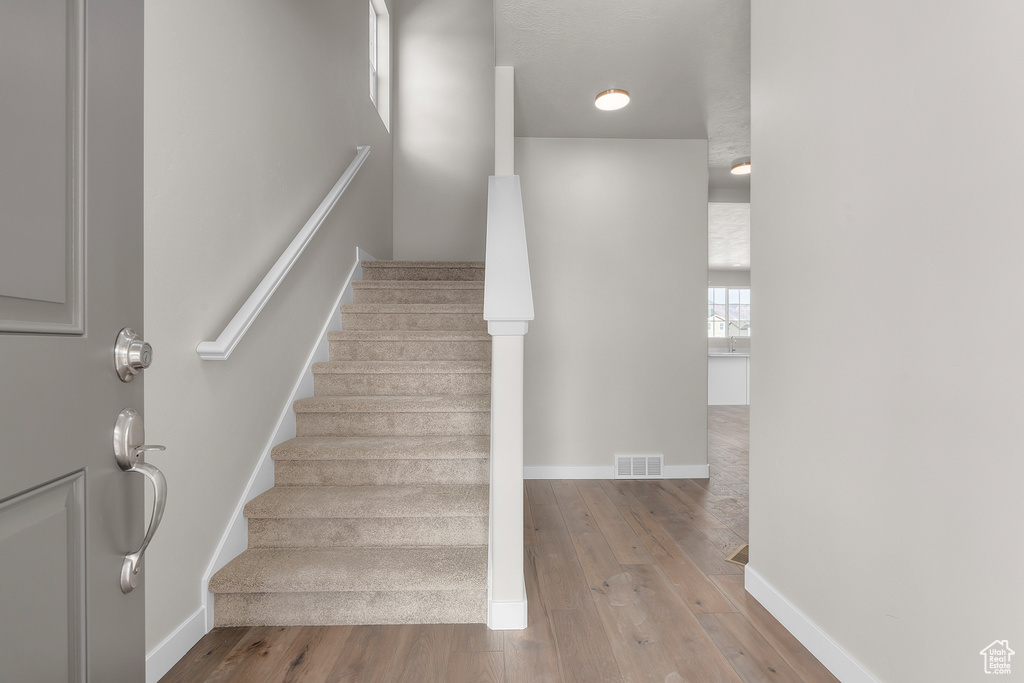 Stairway featuring hardwood / wood-style floors and baseboards