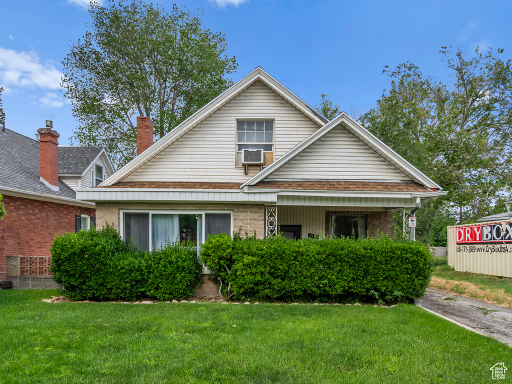 View of front facade with a front yard and cooling unit