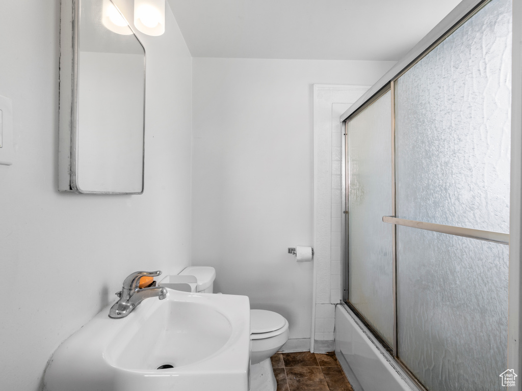 Full bath with a sink, toilet, and enclosed tub / shower combo