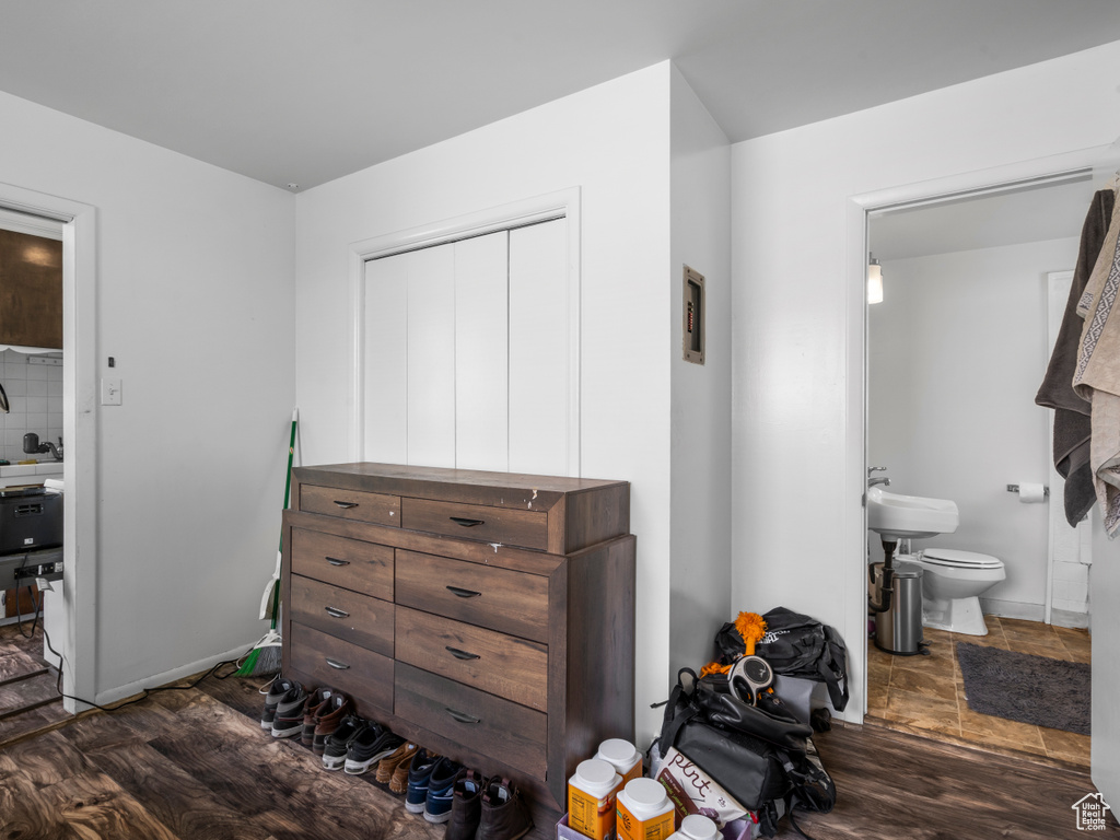 Bedroom featuring ensuite bath and dark wood finished floors