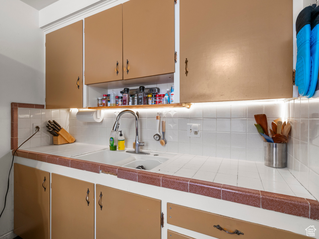 Kitchen featuring backsplash, a sink, and open shelves