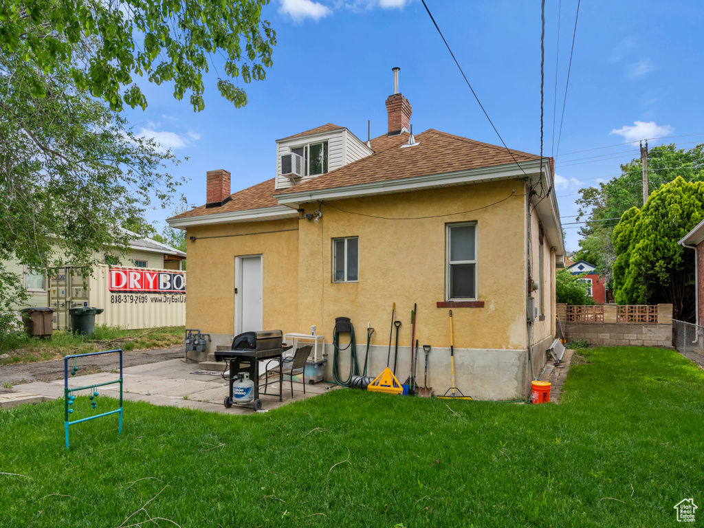 Back of house featuring roof with shingles, stucco siding, a chimney, and a patio area