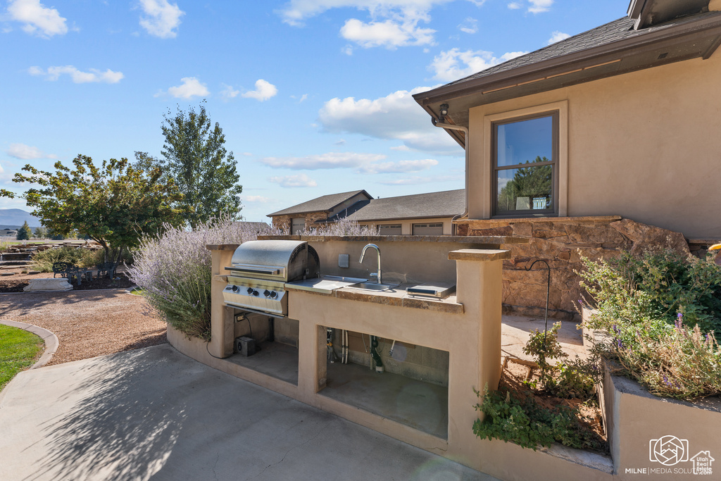 View of patio / terrace with exterior kitchen, area for grilling, and a sink