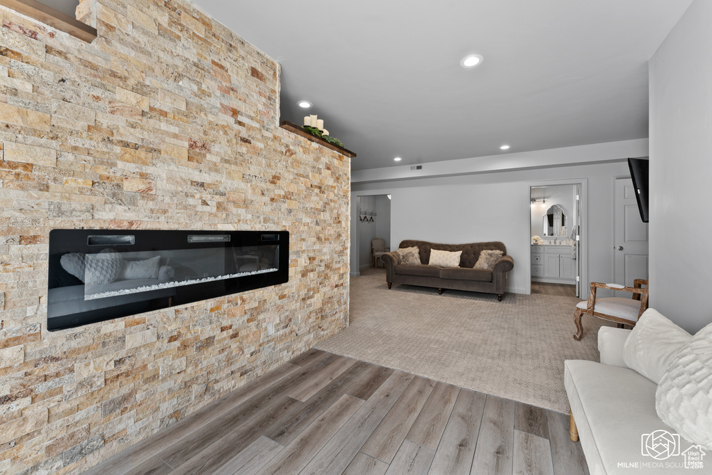 Living room featuring a glass covered fireplace, wood finished floors, and recessed lighting