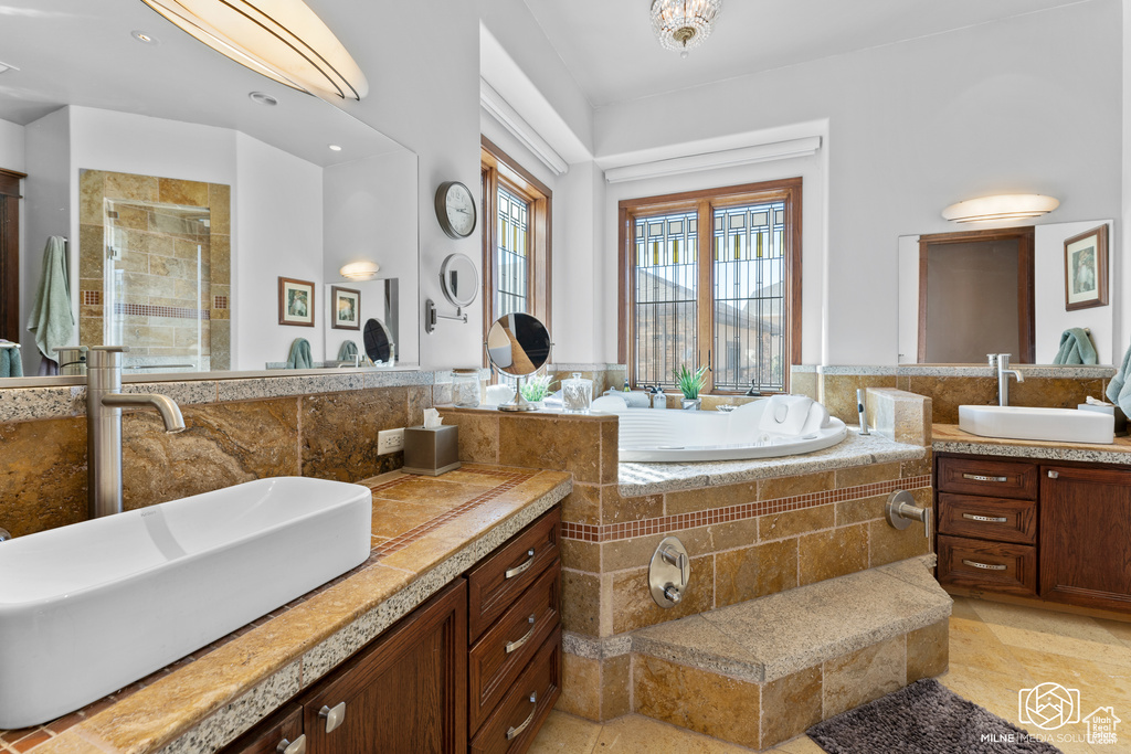 Full bathroom featuring a stall shower, two vanities, and a bath