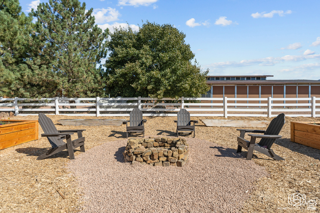 View of yard with an outdoor fire pit and fence