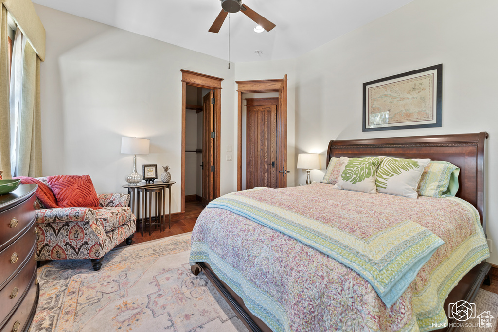 Bedroom with wood finished floors, ceiling fan, and baseboards