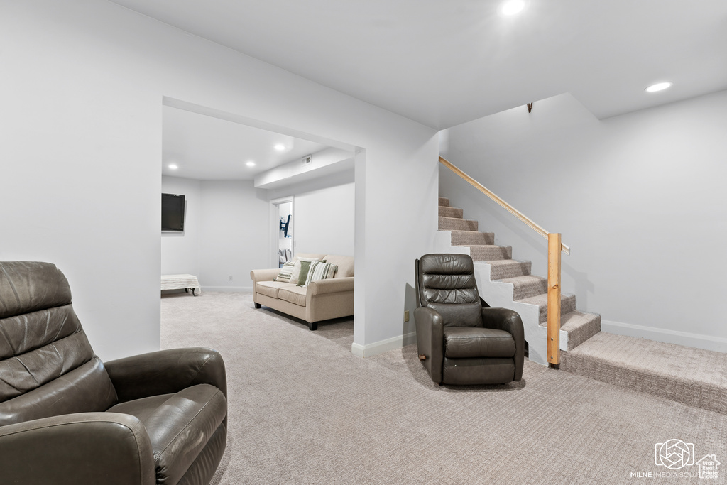 Carpeted living area featuring stairs, recessed lighting, and baseboards