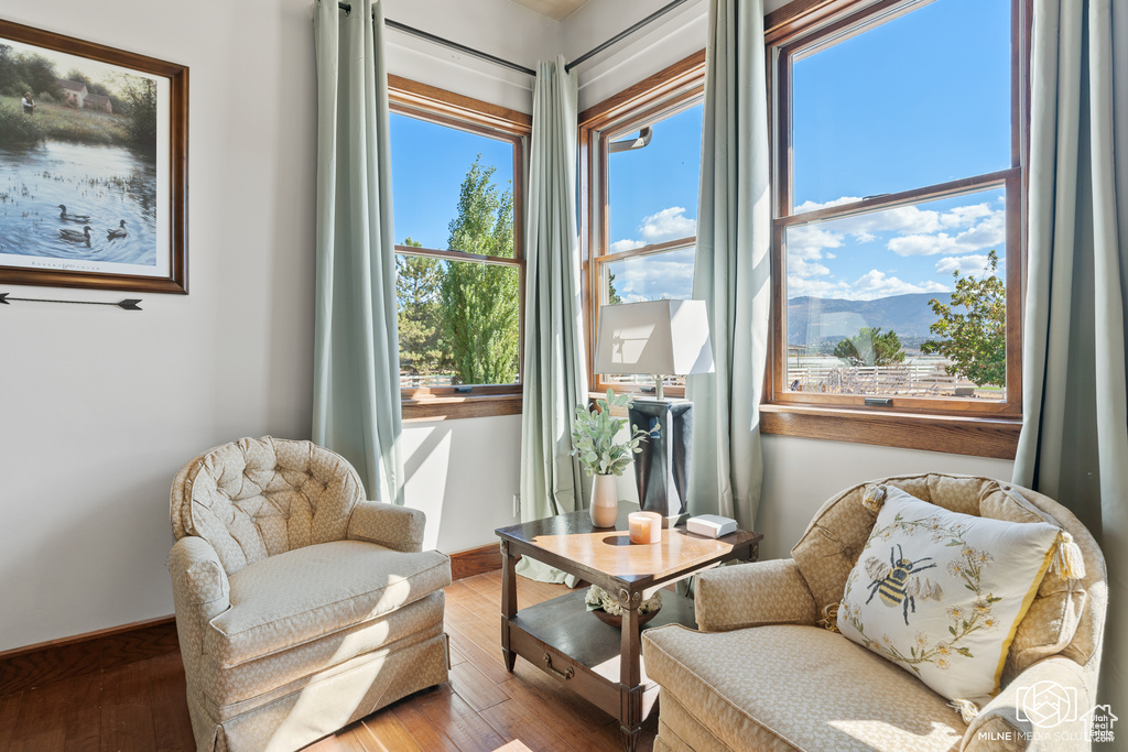Living area featuring healthy amount of natural light, hardwood / wood-style floors, and baseboards