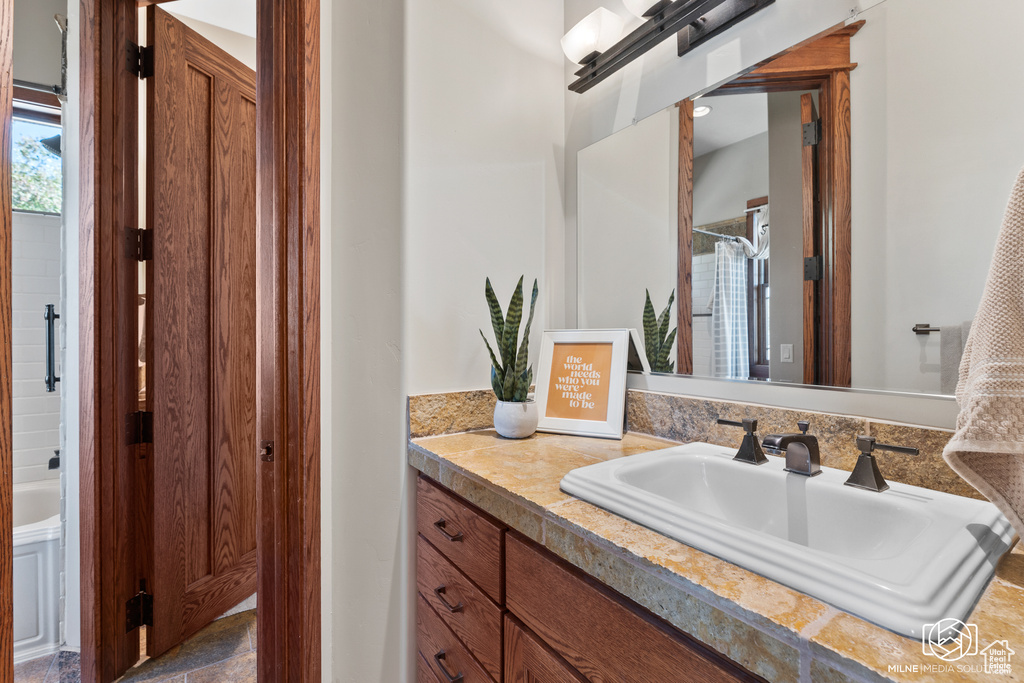 Bathroom featuring vanity and a shower