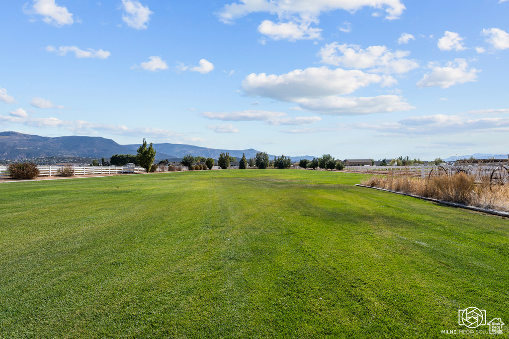 View of green lawn featuring a mountain view and a view of rural / pastoral area