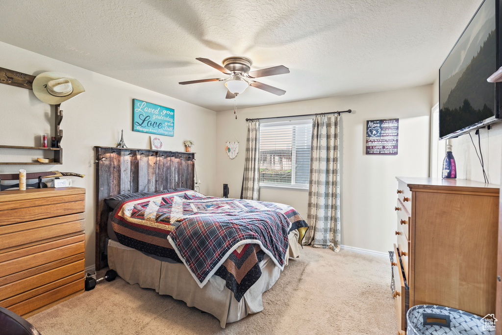 Bedroom with carpet flooring, a ceiling fan, a textured ceiling, and baseboards