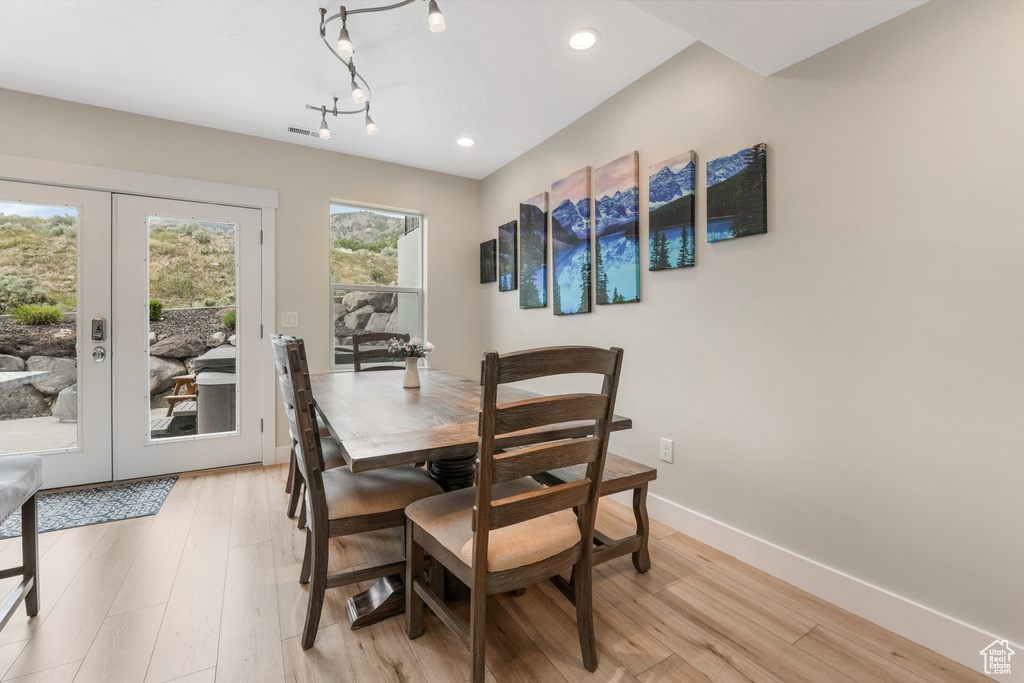 Dining room with french doors, light wood finished floors, baseboards, and recessed lighting