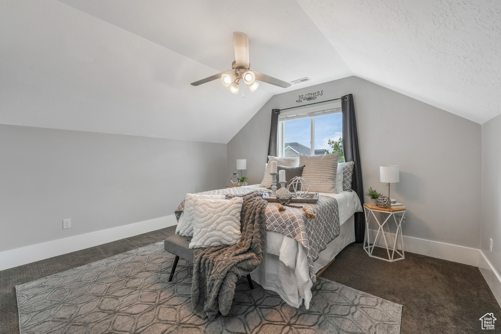 Carpeted bedroom with lofted ceiling, baseboards, and ceiling fan