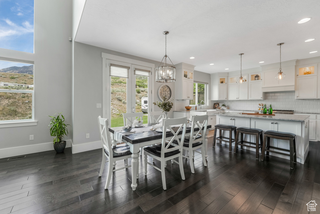 Dining area featuring baseboards, dark wood finished floors, recessed lighting, and a chandelier
