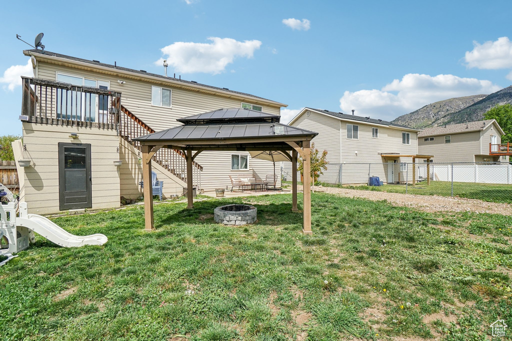 Rear view of house featuring a fire pit, a gazebo, and a mountain view