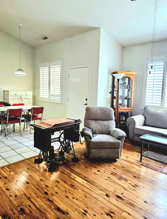 Living area with light wood-style floors and a textured ceiling