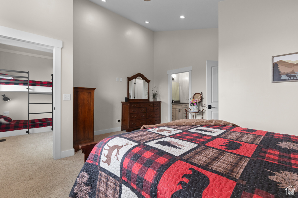 Bedroom with a high ceiling, carpet flooring, recessed lighting, baseboards, and ensuite bath