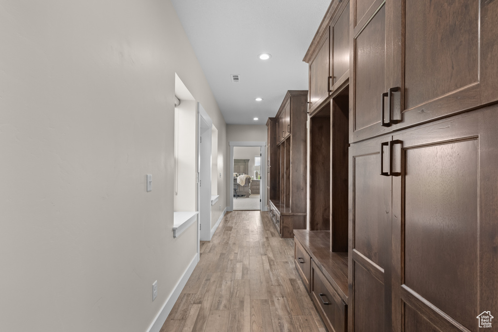 Hall with light wood-style floors, recessed lighting, and baseboards