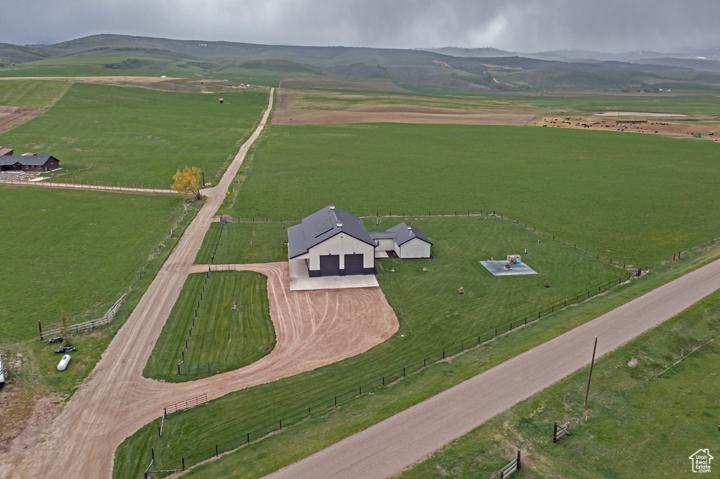 Aerial view of property's location featuring rural landscape, a mountainous background, and agricultural land