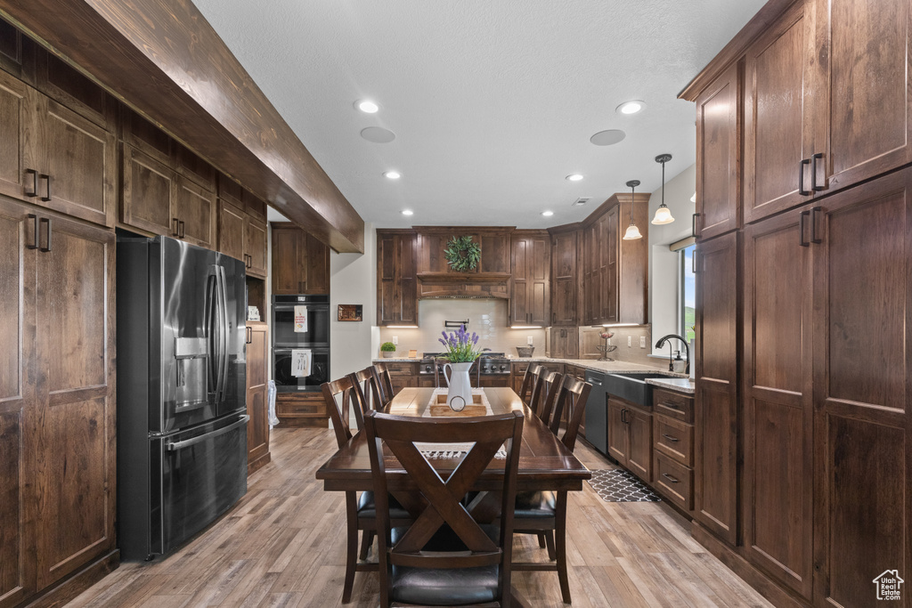 Dining room with light wood finished floors and recessed lighting